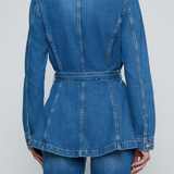 Model wearing a blue denim safari jacket with utility pockets and a button-front design.