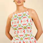 Woman wearing a colorful patterned top against a beige background