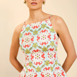 Woman wearing a colorful patterned top against a beige background