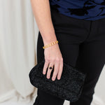 Gold clover bangle with pavé CZ detail, worn on wrist with a softly draped outfit.