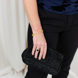 Gold clover bangle with pavé CZ detail, worn on wrist with a softly draped outfit.