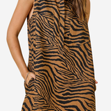 A sleeveless collared dress with a brown and black zebra print, featuring side pockets, shown on a model against a light gray background.