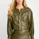 Woman wearing a green leather jacket with decorative cutouts on a white background