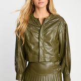Woman wearing a green leather jacket with decorative cutouts on a white background