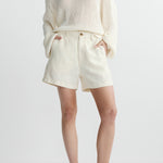 woman in white shorts and sweater on white background 