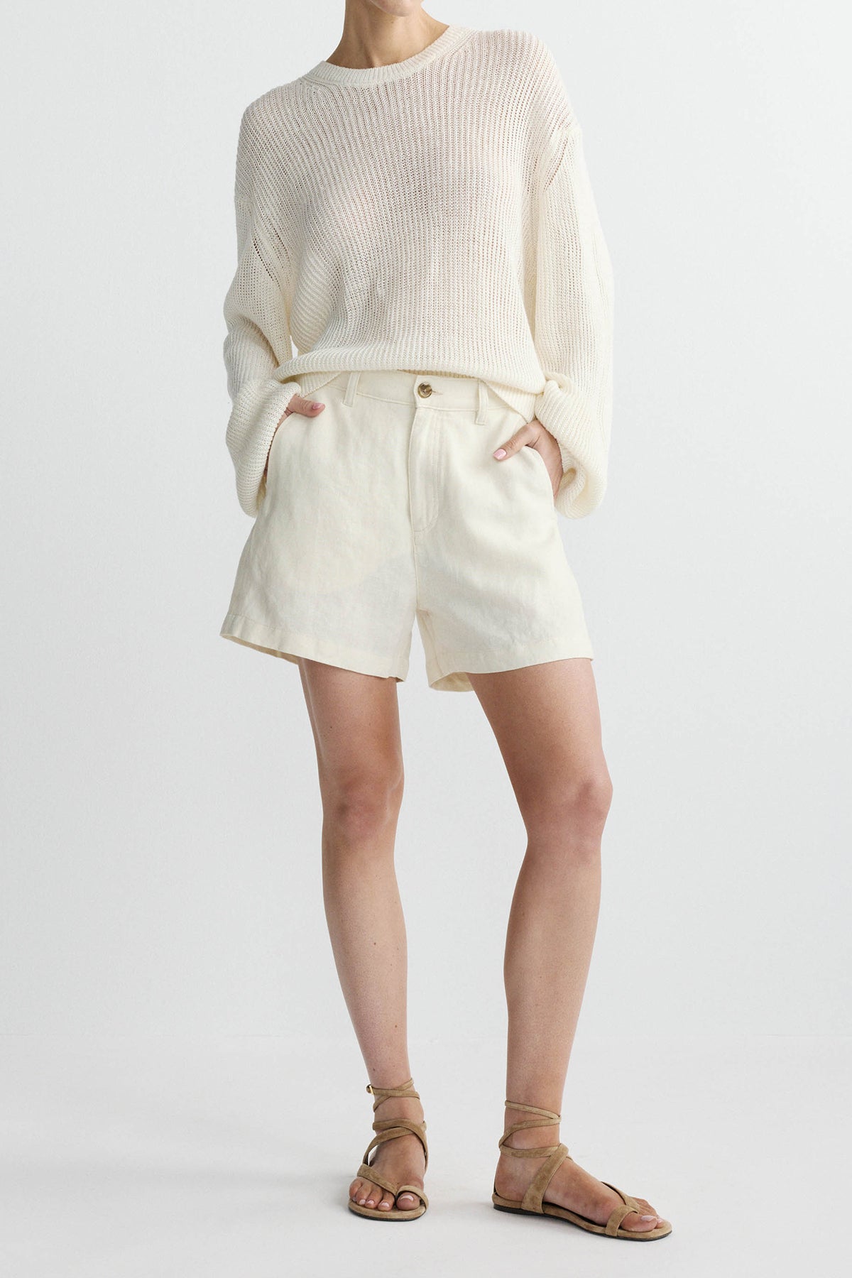 woman in white shorts and sweater on white background 