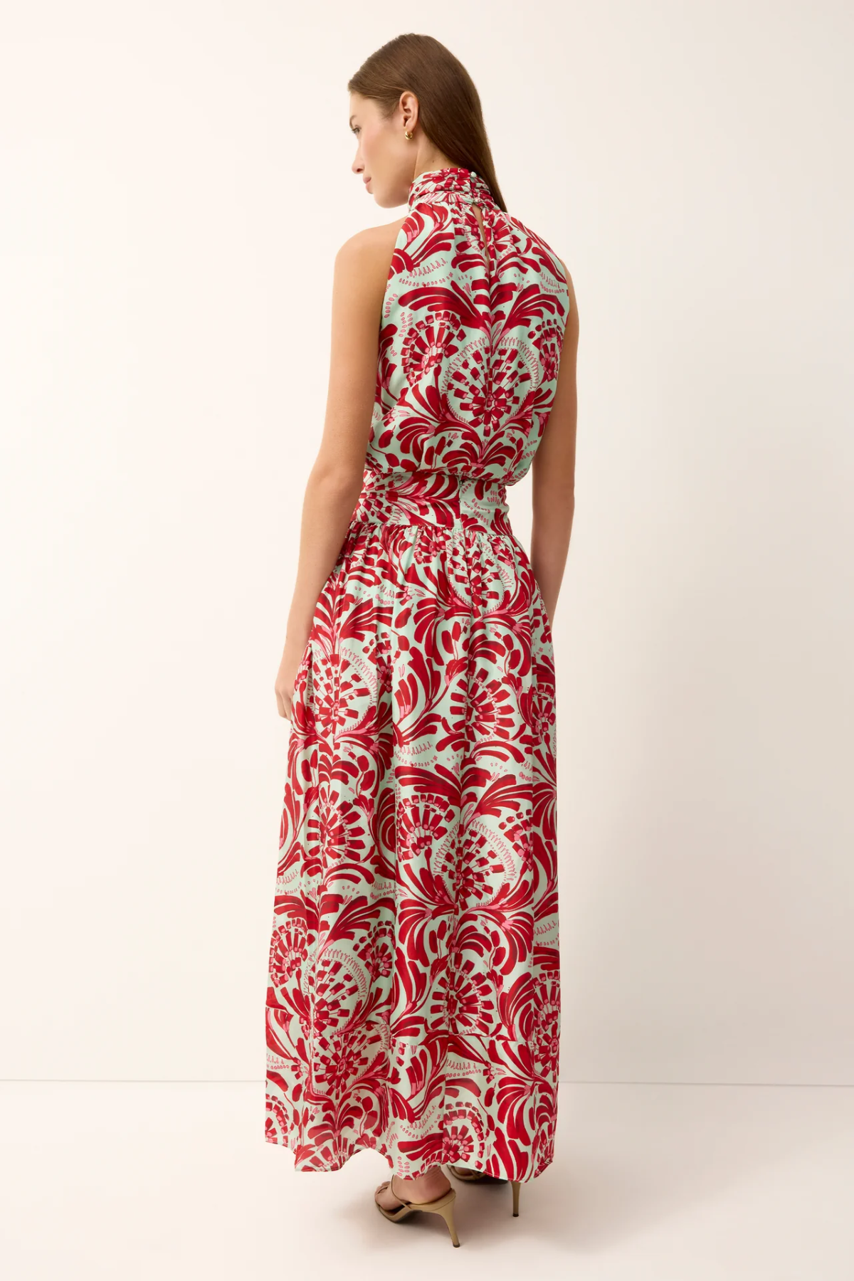 Woman wearing a red and white patterned dress on a white background