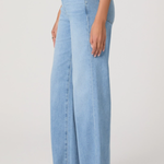 Light blue wide-leg jeans worn by a person on a plain background