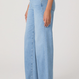 Light blue wide-leg jeans worn by a person on a plain background
