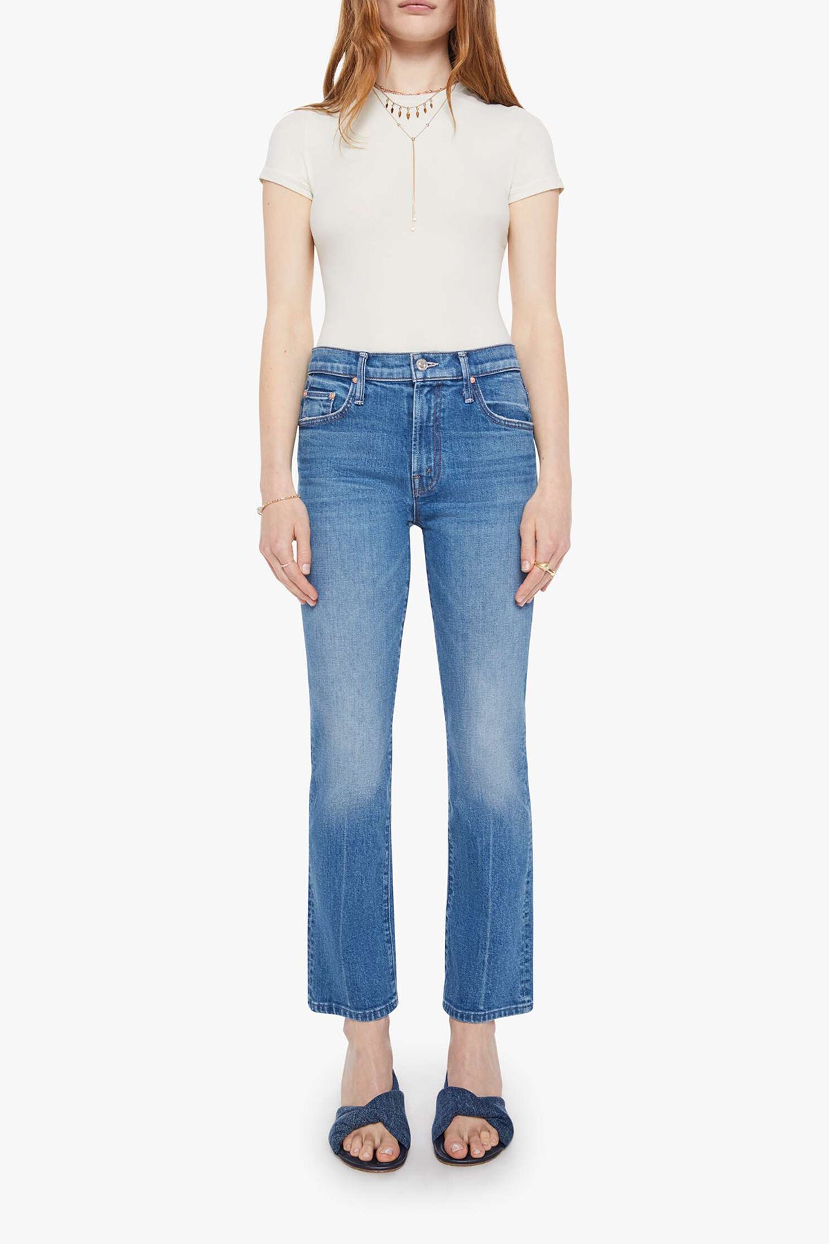 Woman wearing mid-wash cropped flare jeans with a slim upper fit and subtle kick-flare hem.