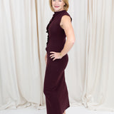 Coordinated burgundy pleated top and skirt set styled for a polished seasonal look