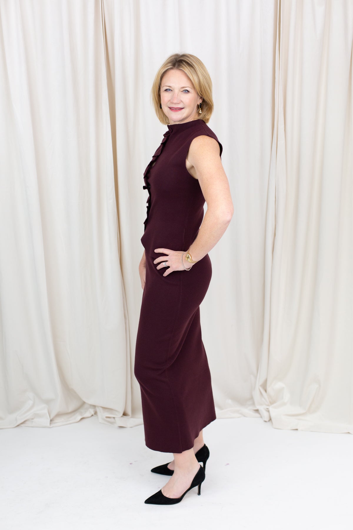 Coordinated burgundy pleated top and skirt set styled for a polished seasonal look