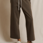 Brown pants with a white drawstring on a neutral background