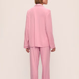 Person wearing a pink pajama set against a beige background