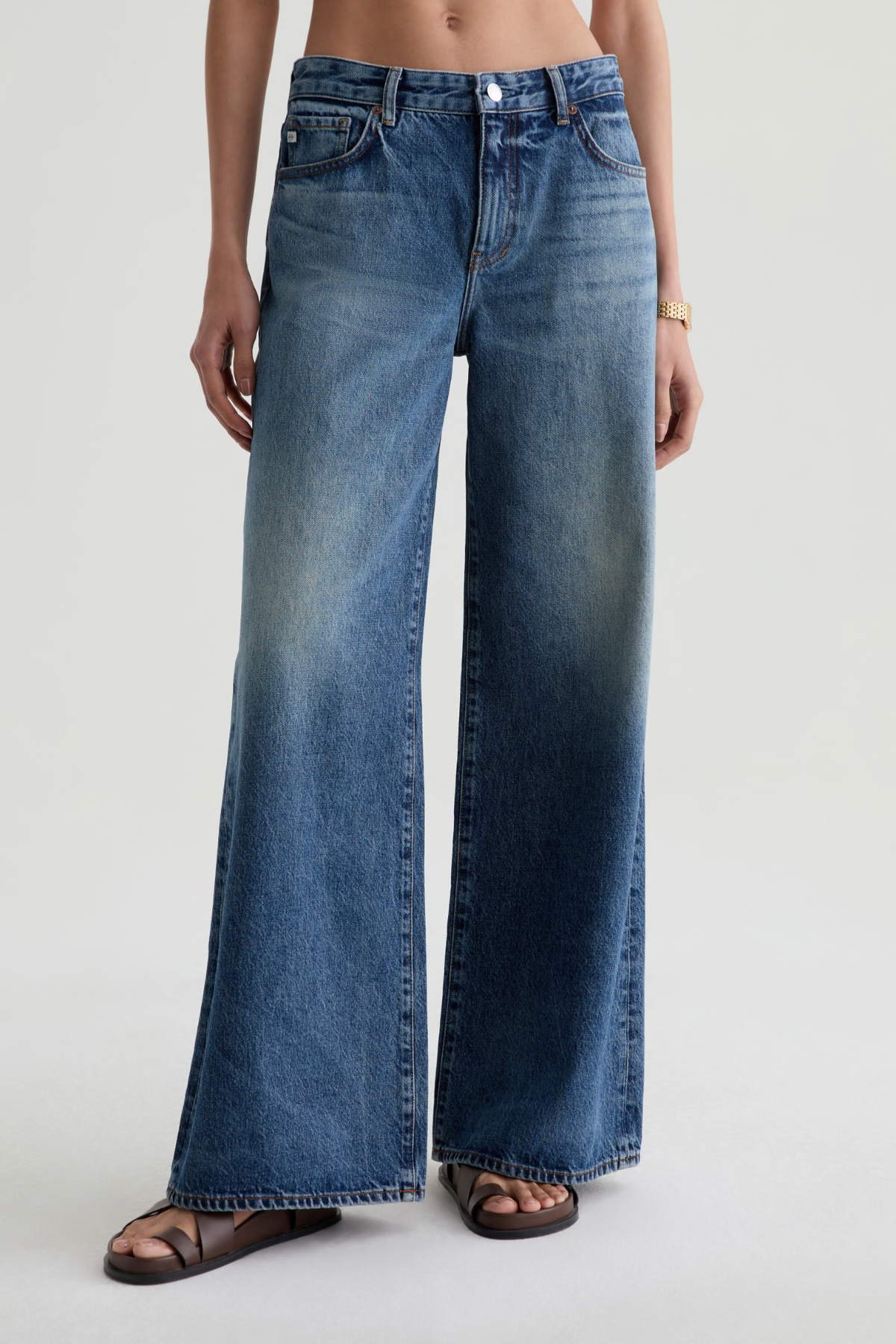 Model wearing high-rise wide-leg denim pants with a relaxed, full-length silhouette.