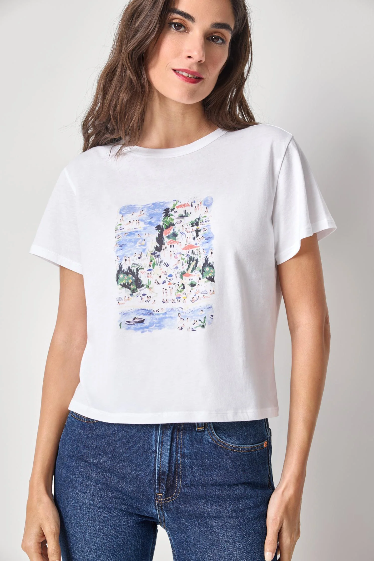 Woman wearing a white t-shirt with a colorful graphic design on a plain background