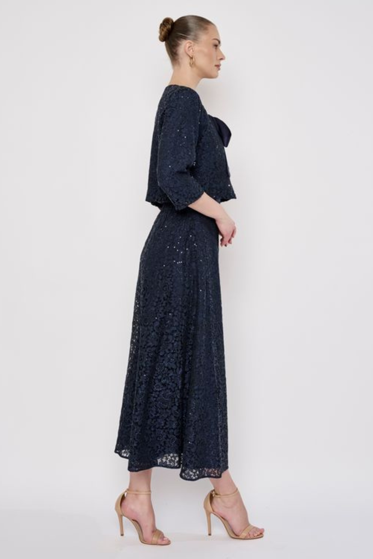 Model wearing a knee-length lace skirt with sequin detailing and a flattering fitted silhouette.