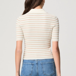 Model wearing a white printed blouse with colorful accents and short sleeves.
