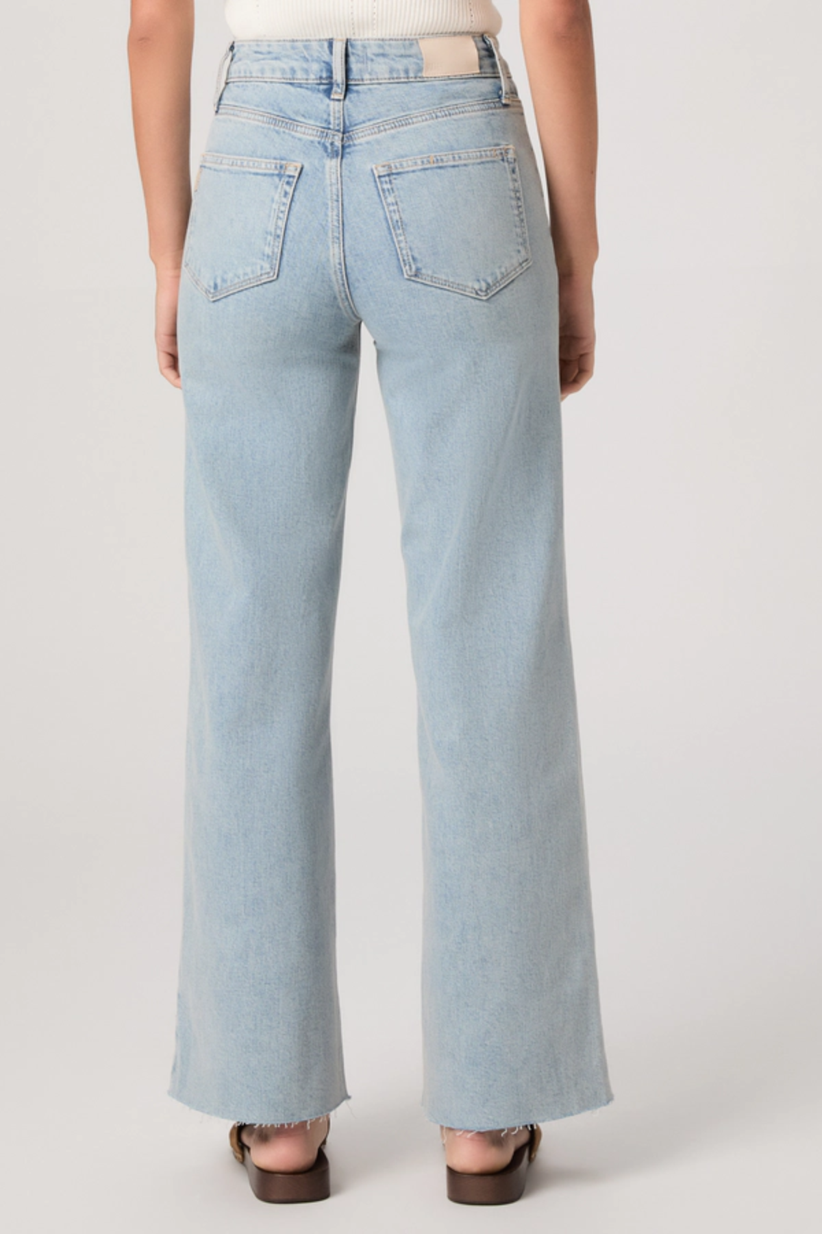 Light blue jeans worn by a person on a white background
