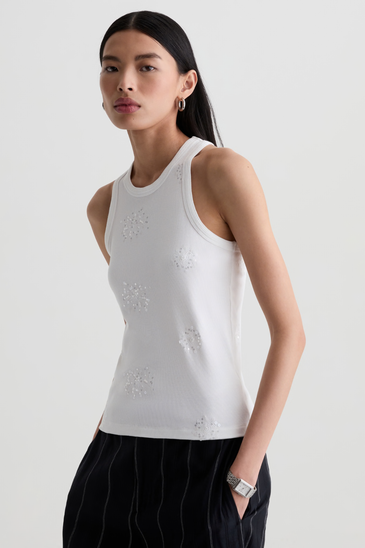 Model wearing a versatile solid-color top with a flattering silhouette styled with tailored black pants.