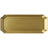 A rectangular gold tray with beveled edges and a recessed center panel featuring the engraved script phrase 'Courage takes courage'.