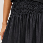 Black smocked top and skirt set on a white background
