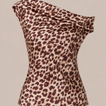 A one-shoulder leopard print top with a draped, cowl-like neckline and a fitted silhouette, shown against a solid beige background.