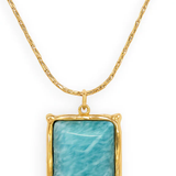 Gold necklace with a rectangular turquoise stone pendant on a white background