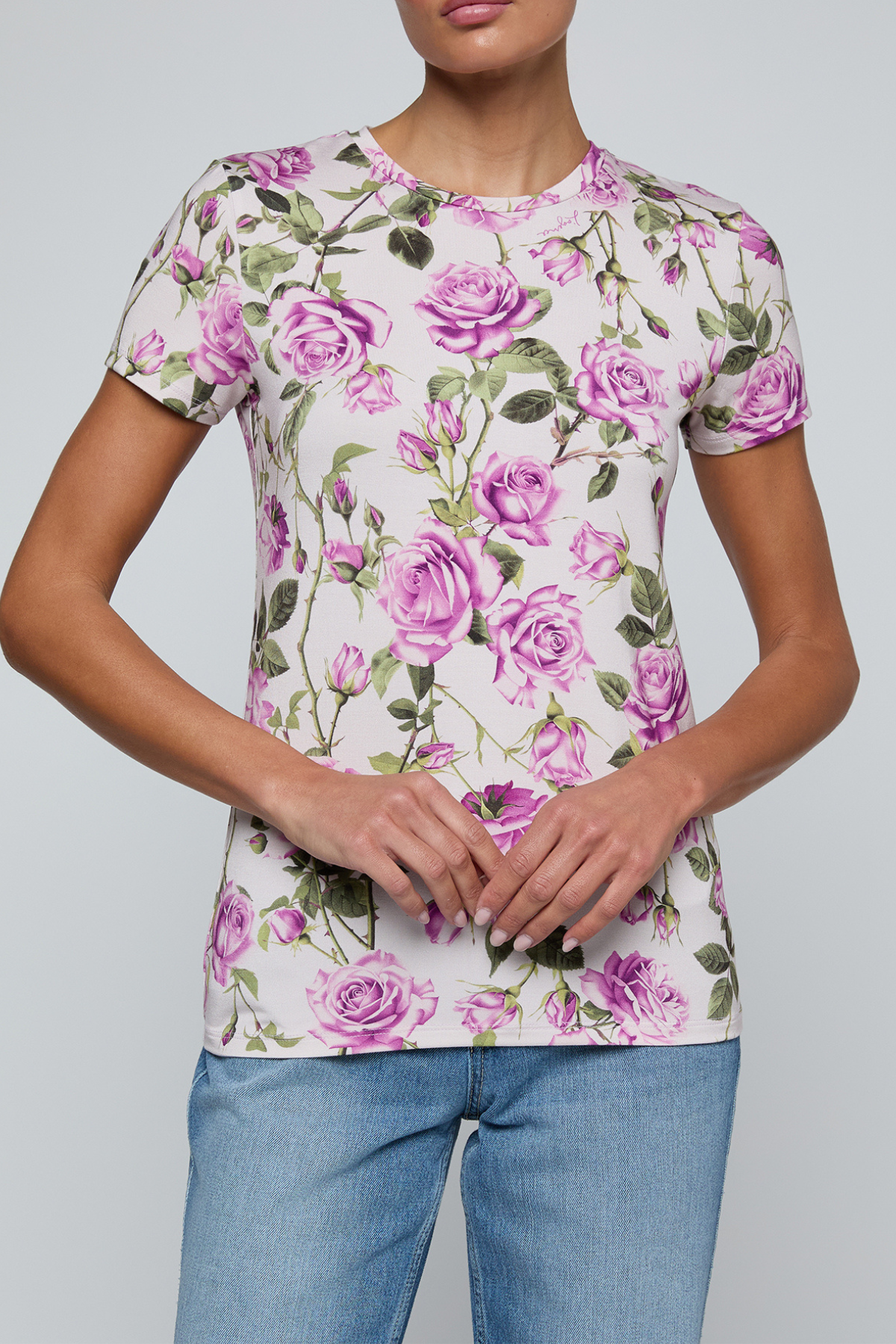 Model wearing rose print tee on a white background.