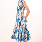 Woman wearing a floral dress with blue and purple flowers on a white background