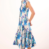 Woman wearing a floral dress with blue and purple flowers on a white background