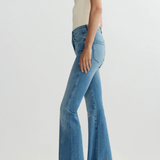 Person wearing blue flared jeans on a white background