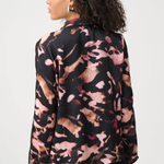 Woman wearing a patterned blouse with a neutral background