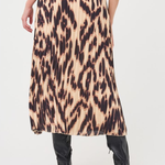A model from the back wearing a pleated midi skirt with a leopard print pattern in beige, brown, and black, paired with black heeled boots against a white studio background.