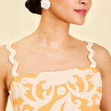 close up of woman in orange embroidered dress