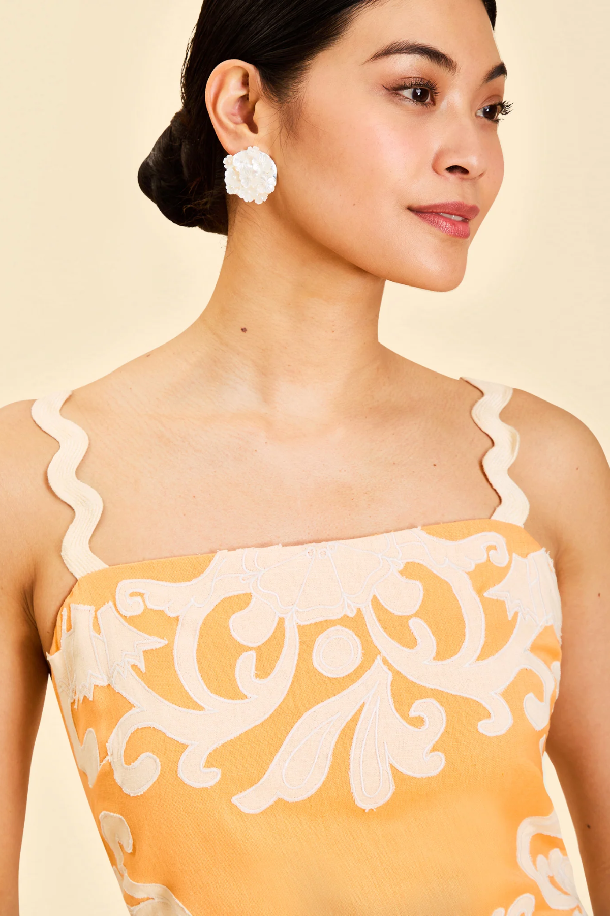 close up of woman in orange embroidered dress