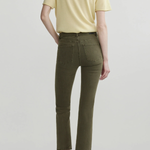 A model shown from the back wearing olive green cropped jeans, a pale yellow t-shirt, and dark brown pointed-toe flats against a light gray studio background.