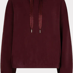 A dark burgundy cropped hoodie with matching drawstrings, displayed against a light gray background.