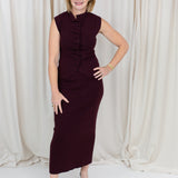 Coordinated burgundy pleated top and skirt set styled for a polished seasonal look