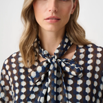 Model wearing a long-sleeve chiffon blouse with a geometric print and tie-neck detail in a relaxed, feminine silhouette.