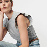woman in ruffle sleeve top and denim 