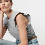 woman in ruffle sleeve top and denim 