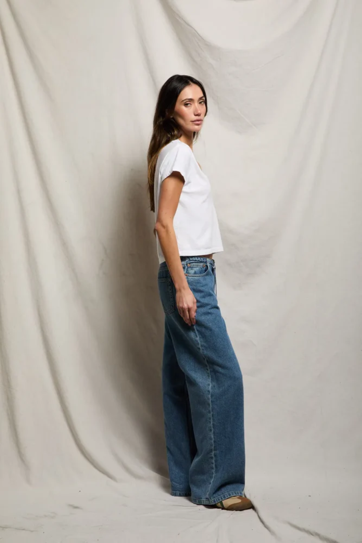 side of woman in white t-shirt and denim 