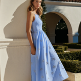 Woman in a blue dress standing in front of classical architecture