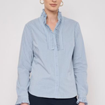 Model wearing a striped long-sleeve blouse with ruffle detailing and a relaxed, polished silhouette.