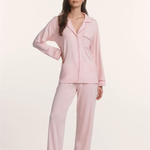Woman wearing a pink pajama set against a white background