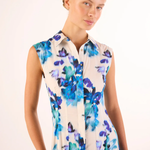 Woman wearing a sleeveless dress with blue floral pattern on a white background