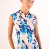 Woman wearing a sleeveless dress with blue floral pattern on a white background