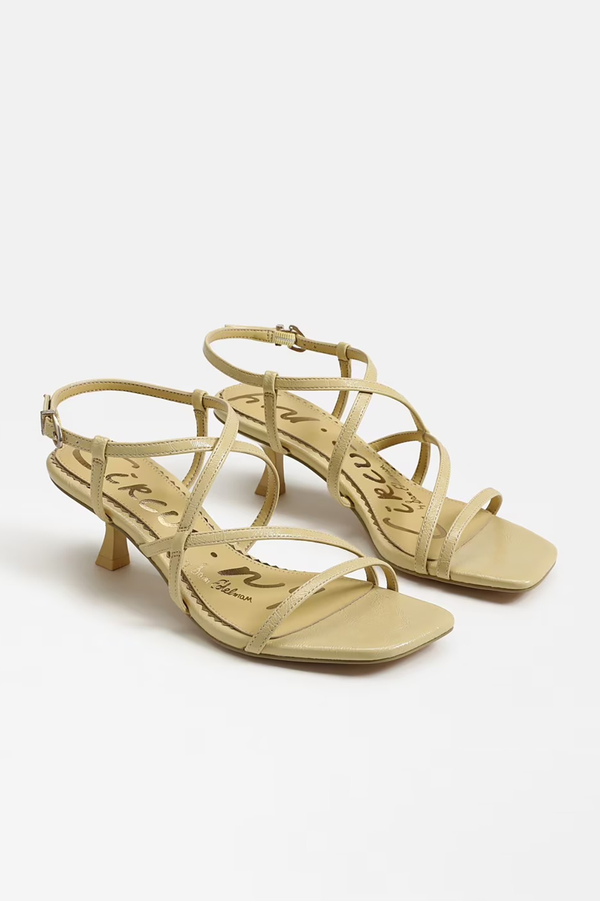 Pair of yellow high-heeled sandals on a white background
