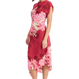 Model wearing a vibrant pink printed short-sleeve midi dress with an asymmetrical hem and flowing silhouette.